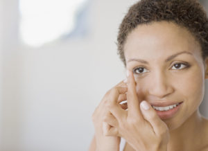 Woman inserting contact lens