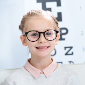 young girl with glasses smiles