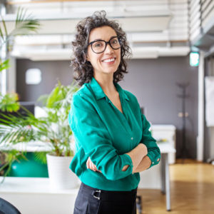 middle aged woman smiles for the camera in her glasses