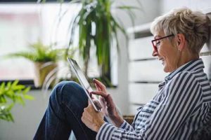 Senior woman using digital tablet at home. The use of technology