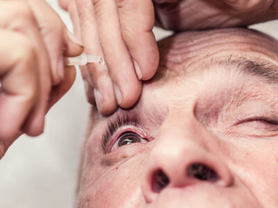 elderly man drip eye drops in eye with medicine dropper glaucoma or cataract therapy concept