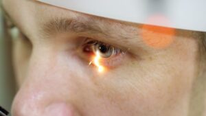 face close-up , man doing eye test with non contact tonometer, cheking vision, intraocular pressure at optical clinic, ophthalmilogical laboratory